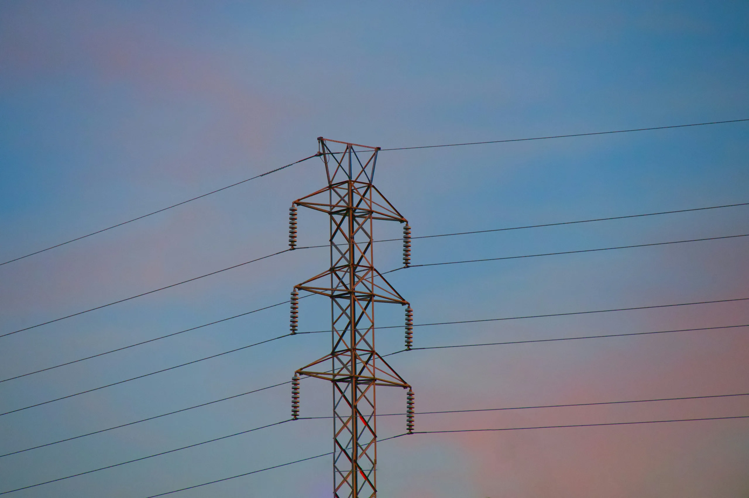 a high voltage power line against a blue sky