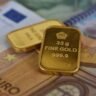 Gold bars and banknotes representing gold price cooling from highs