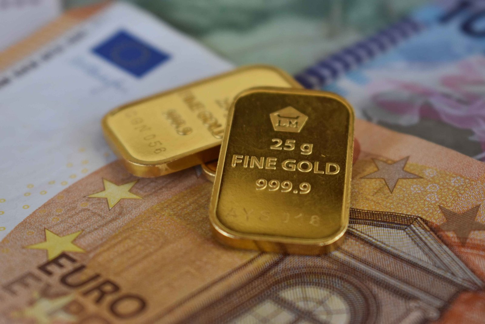 Gold bars and banknotes representing gold price cooling from highs