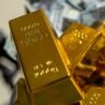 Gold bars on cash background representing Iran Gulf diplomatic talks impact on markets