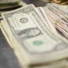 Stack of US dollar bills representing energy sector M&A deals